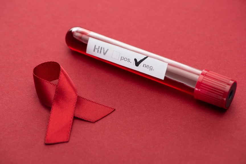 An HIV test tube marked negative beside a red awareness ribbon on a red background